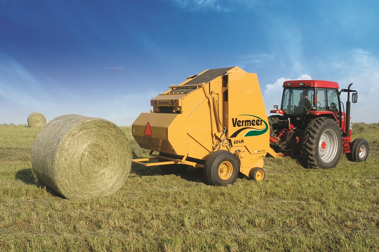 Vermeer 604 Super M Baler in Field with Tractor and Hay Bale
