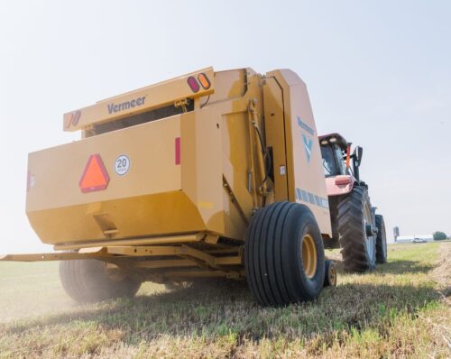 A Vermeer 605S Rancher baler shapes bales in a hay field.