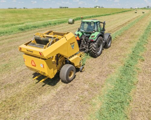 A tractor pulls the new Vermeer Pro G4 silage baler in a field.