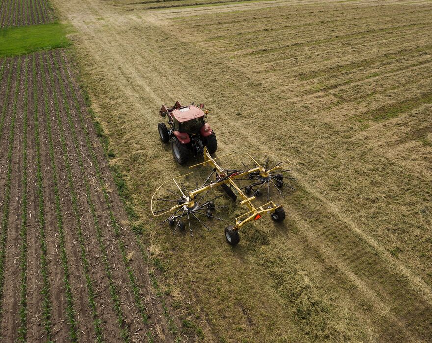 A Vermeer hay rotary rake creating a windrow. 